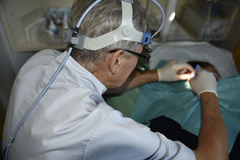 Jarosław Popowski laryngolog wykonuje zabieg dren ucha, wycięcie, pod mikroskopem